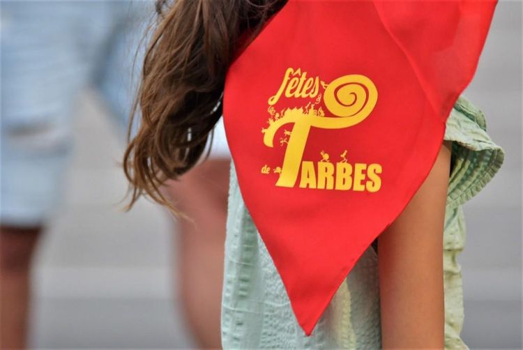 Un bandana rouge marqué Fêtes de Tarbes en jaune